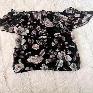 Black floral crop top. Sleeveless. Hangs off of the shoulders